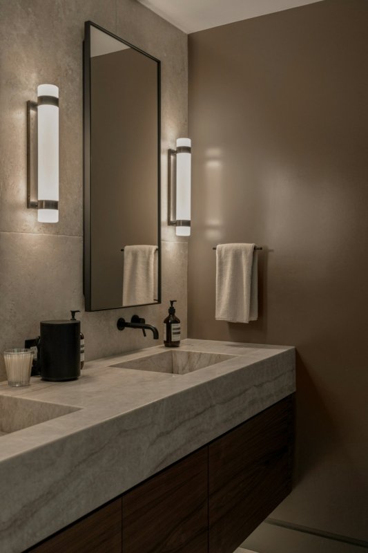 Baño con lámparas de pared a los lados del espejo